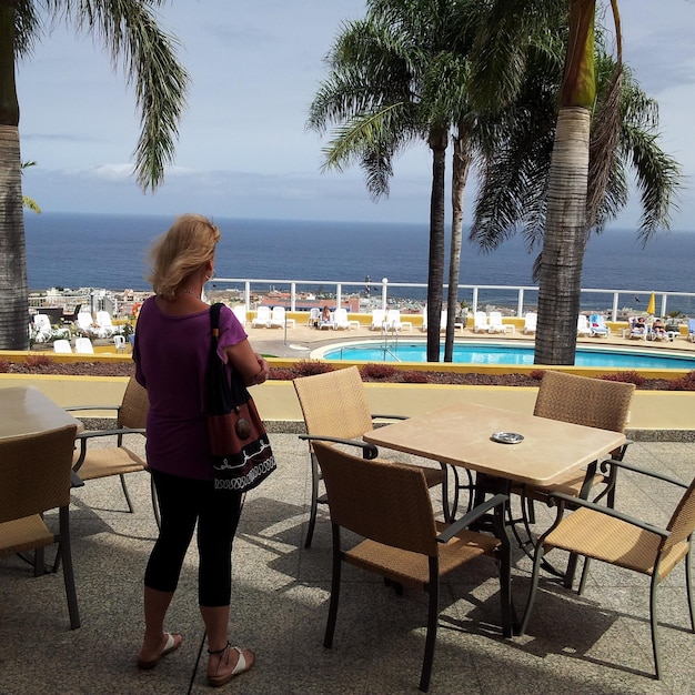 Vista posteriore di una donna in piedi in un ristorante di fronte al mare
