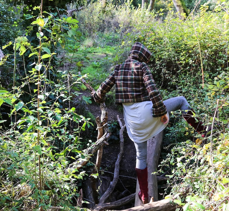 Foto vista posteriore di una donna in piedi sul legno nella foresta
