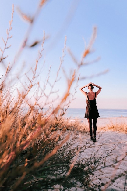 Vista posteriore di una donna in piedi sulla spiaggia