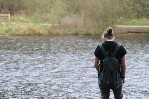 Vista posteriore di una donna in piedi vicino al fiume