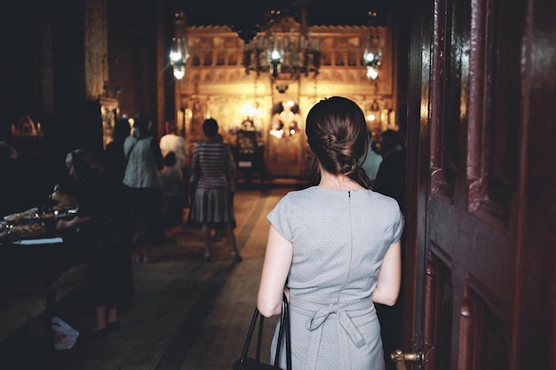 Vista posteriore di una donna in piedi vicino alla porta della chiesa