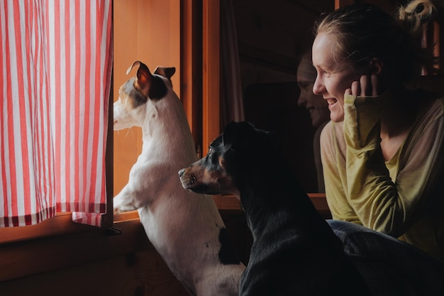 Vista posteriore di una donna seduta a casa con i cani