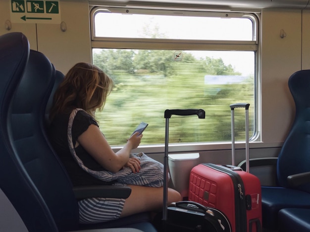 Vista posteriore di una donna seduta sul treno