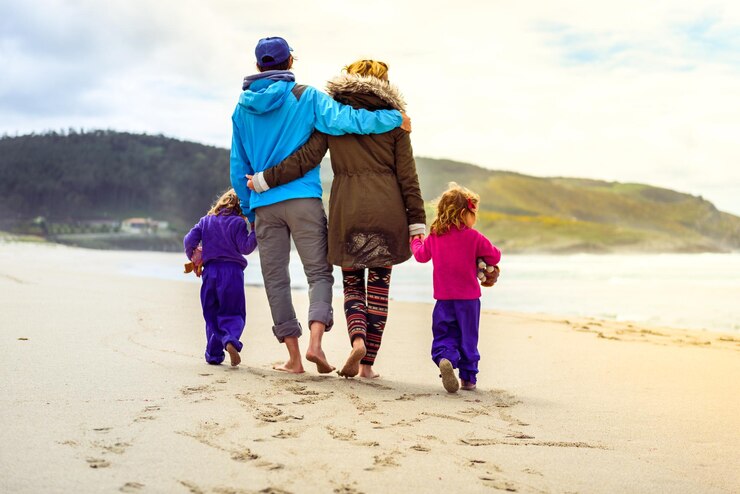 Foto vista posteriore di una famiglia che cammina sulla spiaggia