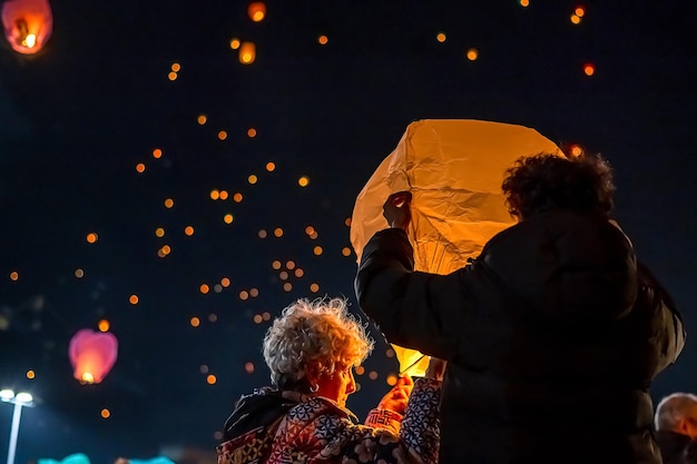 Vista posteriore di una famiglia che desidera e getta lanterne nel cielo.