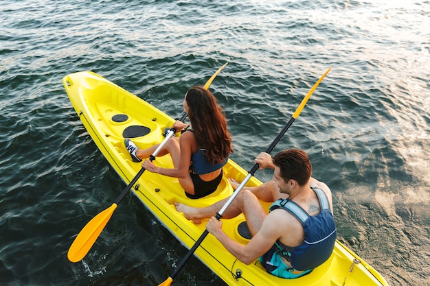 Vista posteriore di una giovane coppia in kayak sul lago