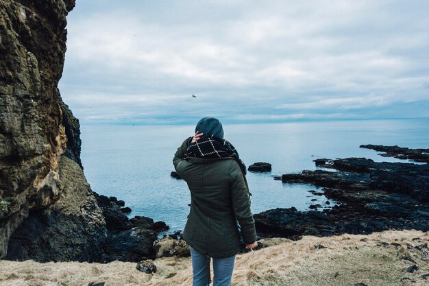 Vista posteriore di una persona in piedi contro il mare