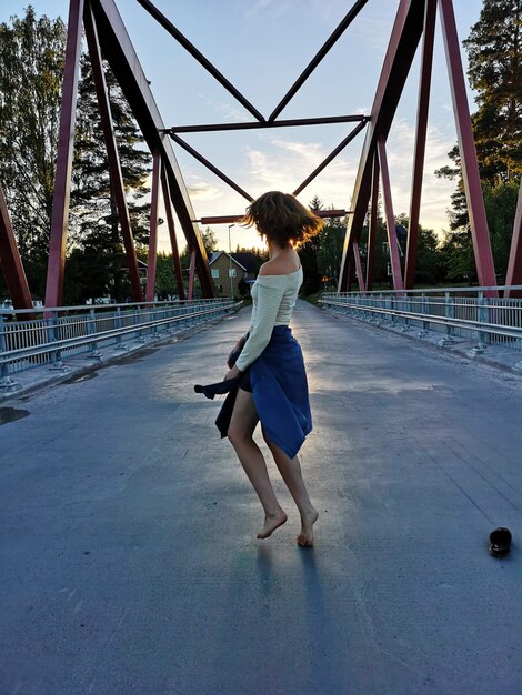 Vista posteriore di una ragazza che balla sul ponte