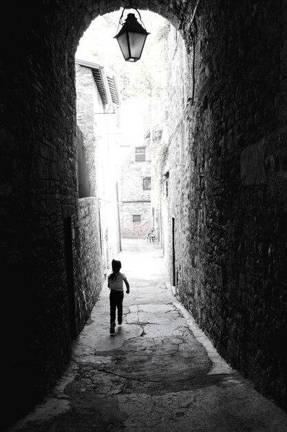 Vista posteriore di una ragazza che cammina sul vicolo