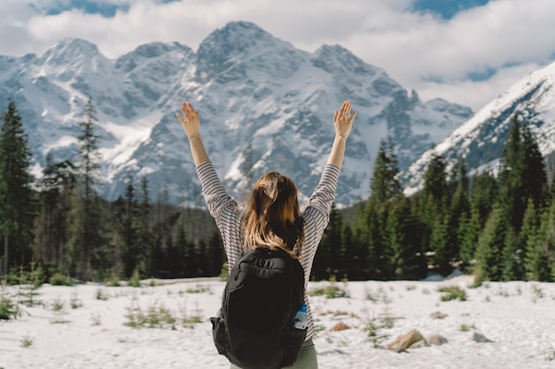 Vista posteriore di una ragazza che indossa uno zaino che viaggia da sola nella valle dei monti Tatra nel paese della Polonia