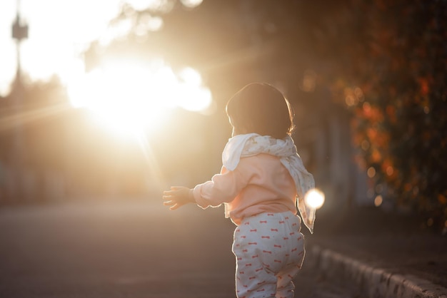 Vista posteriore di una ragazza in piedi sulla terra durante il tramonto