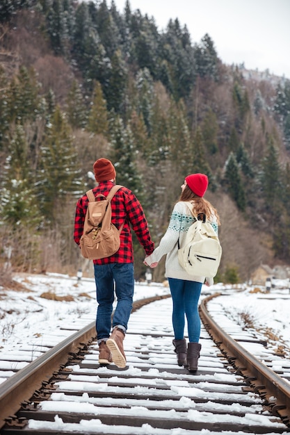Vista posteriore ritratto di una coppia che cammina sulla ferrovia