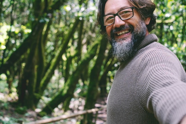 Vista POV dell'uomo che sorride e si diverte con gli alberi verdi della natura e la foresta sullo sfondo Persone che si godono i boschi del parco nazionale con gli amici o da soli Ambiente e attività ricreative alternative