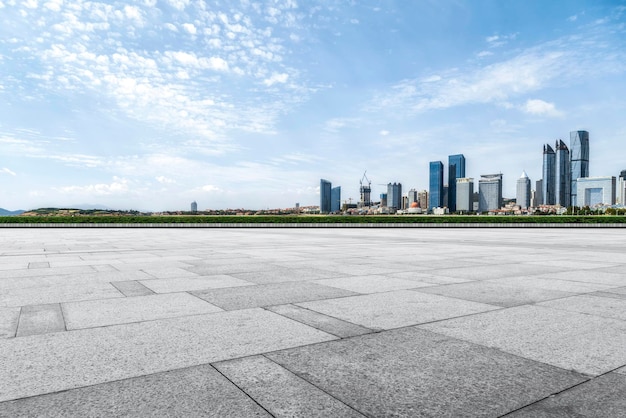 Vista prospettica del pavimento vuoto delle piastrelle di cemento del tetto con lo skyline della città