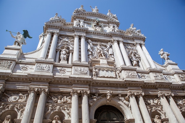 Vista prospettica facciata antiquata del palazzo storico della cattedrale di Venezia, Italia su uno sfondo di cielo blu.