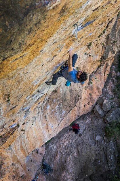 Vista ravvicinata ad alto angolo di un uomo che si arrampica su una montagna