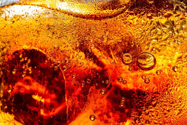 Vista ravvicinata dei cubetti di ghiaccio sullo sfondo scuro della cola Texture di bevanda rinfrescante estati dolci