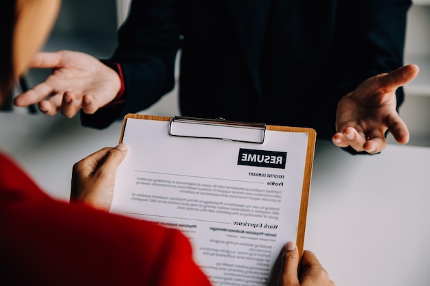 Vista ravvicinata del colloquio di lavoro in ufficio attenzione alla scrittura del curriculum consigli datore di lavoro che esamina un buon curriculum di un candidato qualificato preparato reclutatore che prende in considerazione l'applicazione HR manager che prende la decisione di assunzione