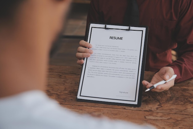 Vista ravvicinata del colloquio di lavoro in ufficio concentrarsi sui suggerimenti per la scrittura del curriculum datore di lavoro che esamina il buon cv del reclutatore di candidati qualificati preparati considerando la candidatura del responsabile delle risorse umane che prende la decisione di assunzione