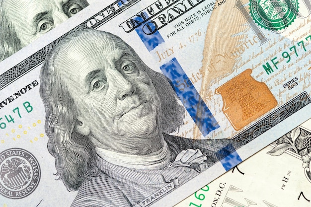 Vista ravvicinata del denaro contante in dollari americani sullo sfondo delle bollette con il ritratto di Benjamin Franklin. Finanza e concetto di affari. Avvicinamento. Profondità di campo.