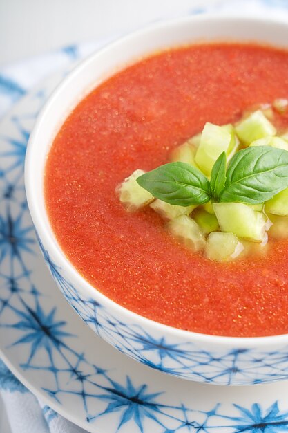 Vista ravvicinata del gazpacho fresco freddo rinfrescante zuppa di pomodoro fatta di verdure crude con foglie di basilico