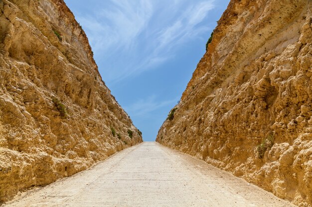 Vista ravvicinata della formazione rocciosa. Un sentiero nel deserto tra muri di pietra levigata.