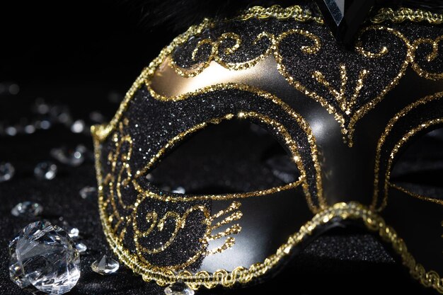 Vista ravvicinata della maschera d'oro di Masquerade con pietre preziose su sfondo nero