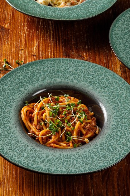 Vista ravvicinata della pasta con carne macinata sul tavolo di legno