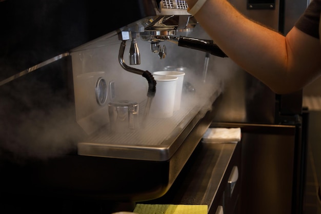 Vista ravvicinata della preparazione del caffè espresso nella macchina da caffè automatica nella caffetteria