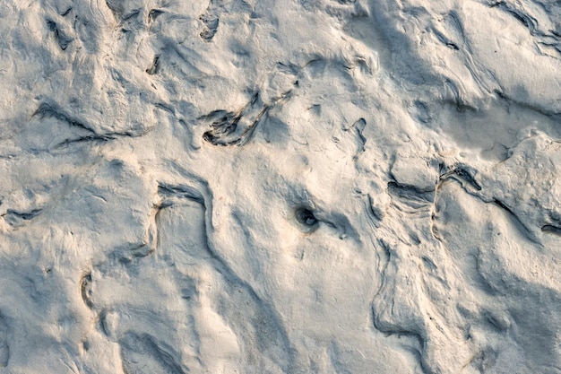 Vista ravvicinata della trama di sabbia bagnata sulla riva del fiume