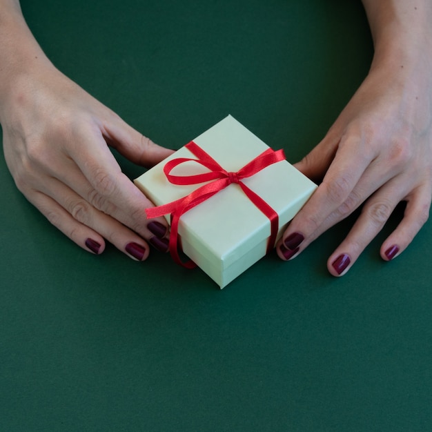 Vista ravvicinata delle mani della donna che tengono uno spazio di scatola regalo per il testo