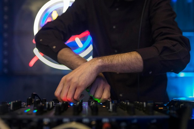 Vista ravvicinata delle mani di un djs che suonano il mixer durante l'esecuzione