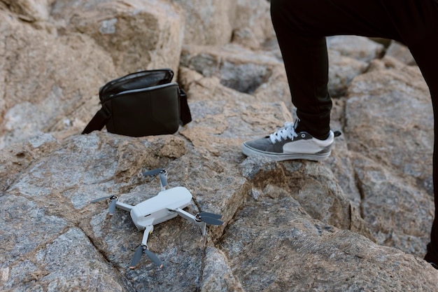 Vista ravvicinata delle mani di un giovane che aziona un drone sul mare