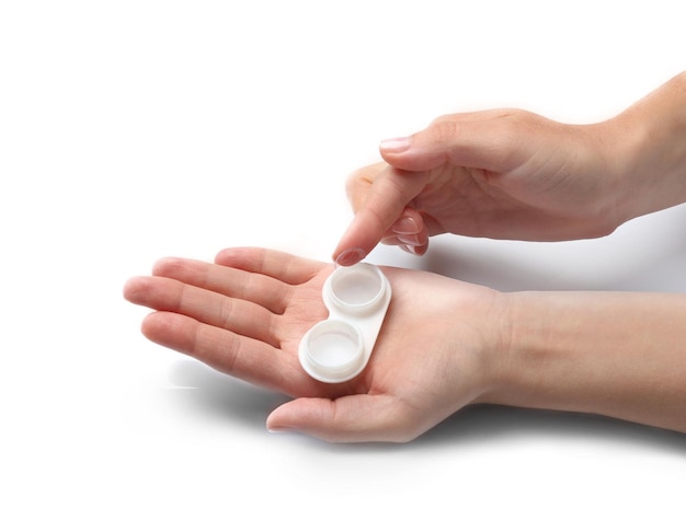 Vista ravvicinata delle mani femminili che prendono la lente dal contenitore su sfondo chiaro