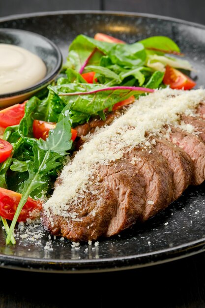 Vista ravvicinata di bistecca a fette con parmigiano e verdure fresche