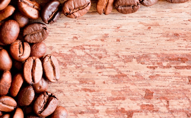 Vista ravvicinata di chicchi di caffè tostati, vecchio sfondo di legno