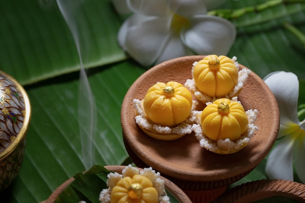 Vista ravvicinata di diversi dessert tradizionali tailandesi serviti su foglie di banana