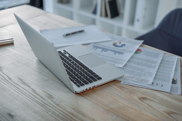 Vista ravvicinata di laptop e documenti sul tavolo sul posto di lavoro