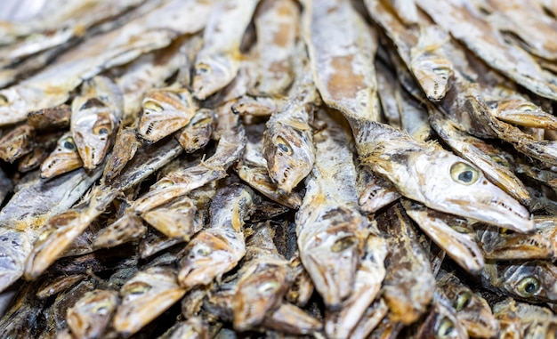 Vista ravvicinata di un mucchio di pesce di mare essiccato su un mercato di frutti di mare con messa a fuoco selettiva