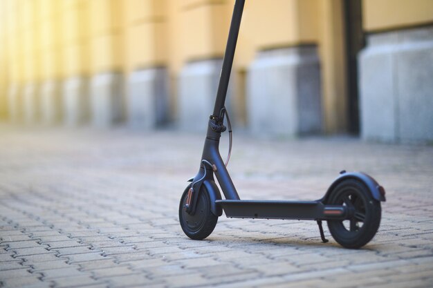 Vista ravvicinata su scooter elettrico sulla piastrella di una strada di città in una giornata di sole