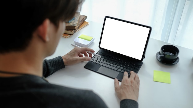 Vista ravvicinata uomo libero professionista che lavora su tablet computer a casa.