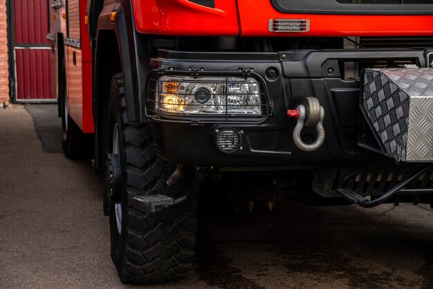 Vista ritagliata del camion dei pompieri di colore rosso con scale retrattili in piedi nel garage. Concetto di emergenza