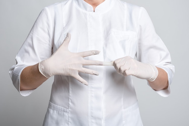 Vista ritagliata del medico in guanti di lattice bianchi per virus protettivo. Proteggiti