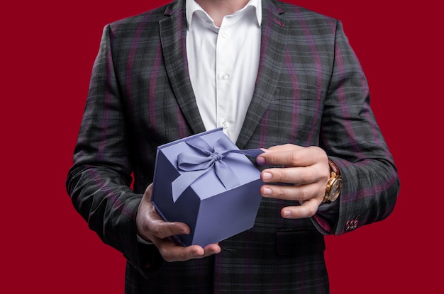 vista ritagliata dell'uomo che tiene la proposta di regalo in studio uomo con proposta di regalo foto dell'uomo in possesso della proposta di regalo uomo con offerta di proposta di regalo isolato su sfondo rosso