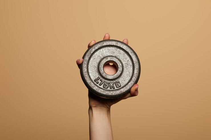 Foto vista ritagliata della donna che tiene il peso isolato sul beige
