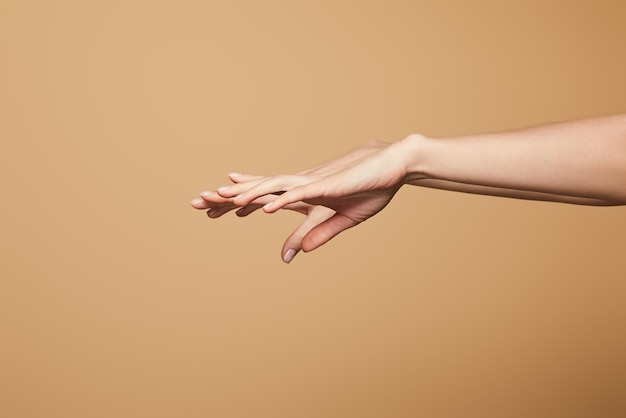 Vista ritagliata delle mani delicate femminili isolate sul beige