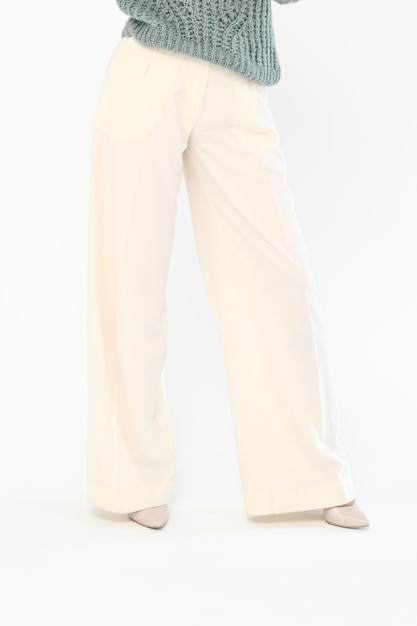 Vista ritagliata di donna elegante in pantaloni leggeri isolati su sfondo bianco Foto verticale
