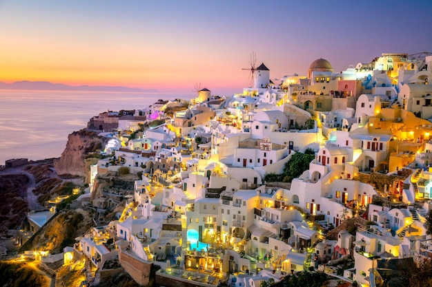 Vista serale al tramonto del villaggio greco tradizionale Oia sull'isola di Santorini in Grecia Santorini è una destinazione di viaggio iconica in Grecia famosa per i suoi tramonti e la tradizionale architettura bianca