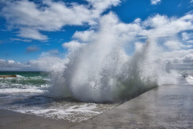 Vista spettacolare delle onde del mare che si infrangono contro il molo di cemento