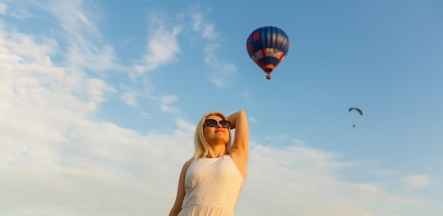 Vista straordinaria con donna e mongolfiera. Immagine artistica. Mondo della bellezza. La sensazione di completa libertà